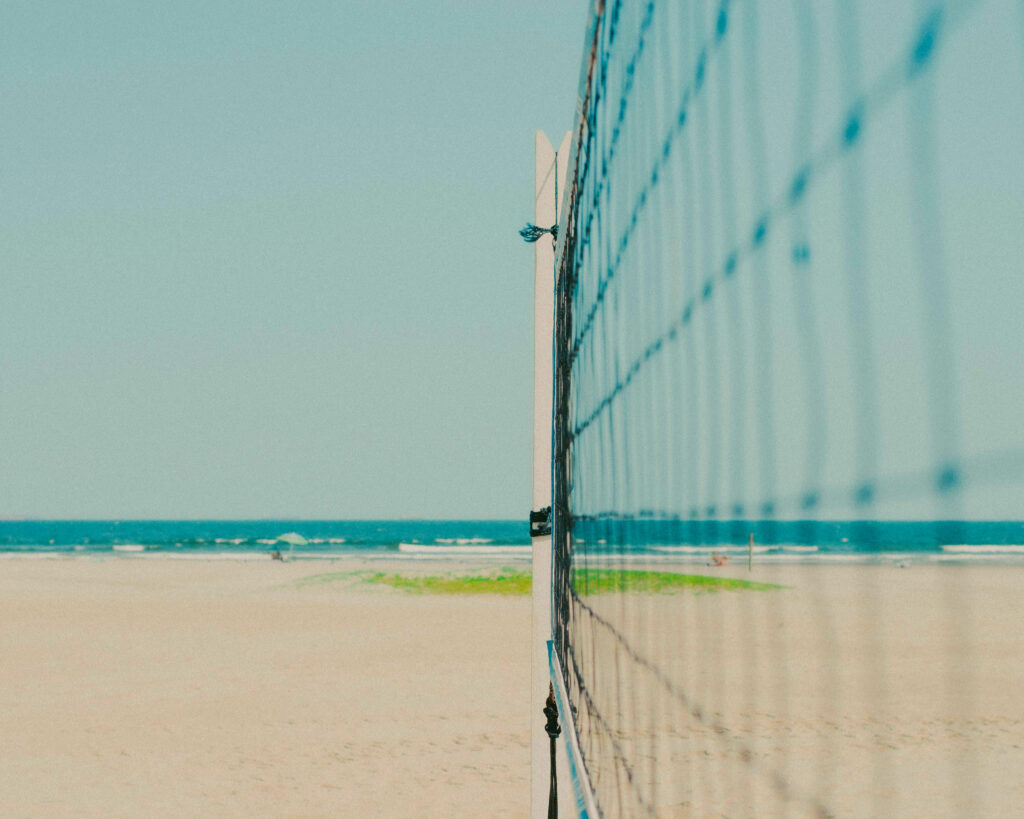 Beach tennis match being played on white sand courts by the Caribbean sea